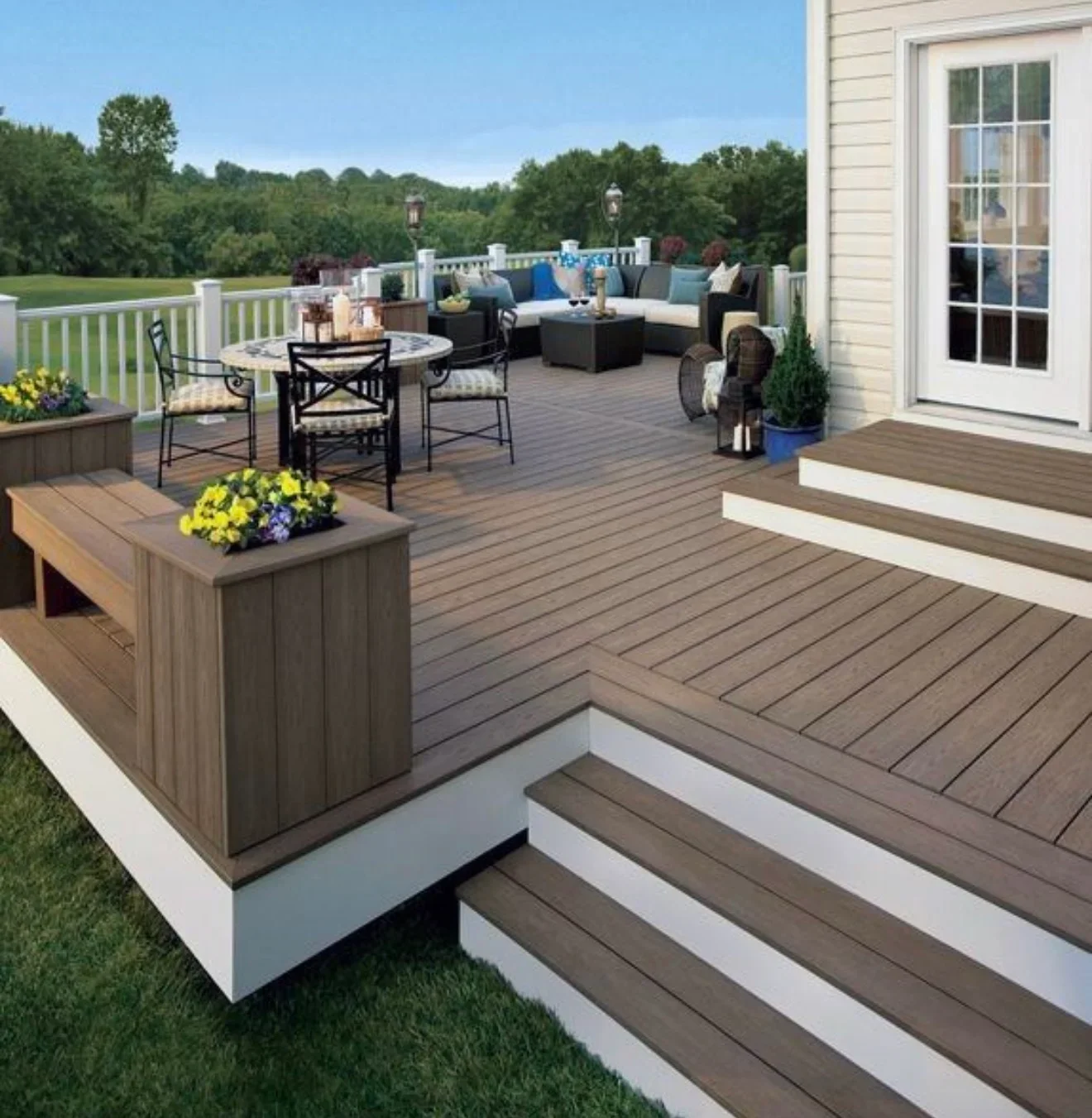 Multi-level composite deck with white railings, built-in planter, and outdoor seating areas