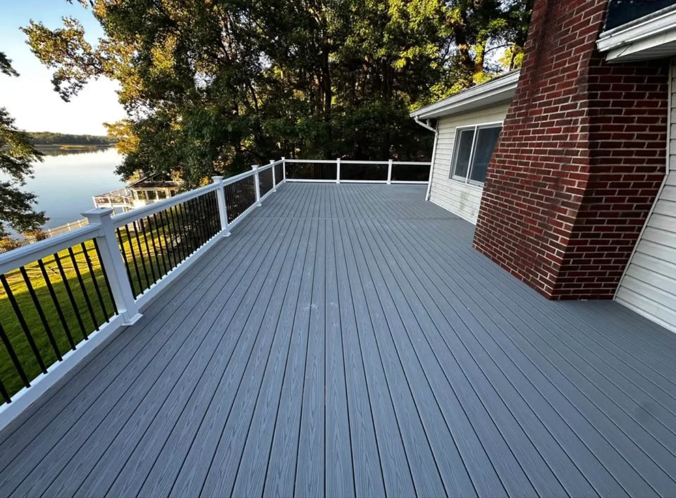 Gray composite waterfront deck with white and black cable railing system