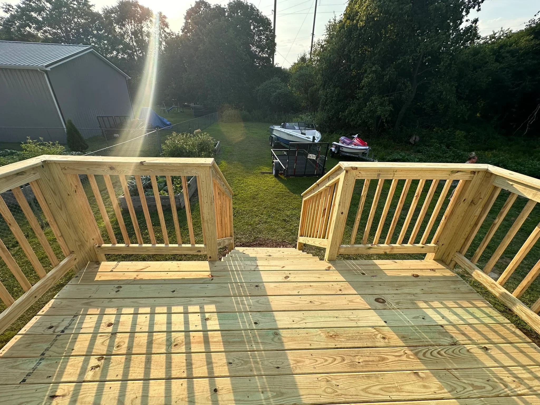 New composite deck with wood railings overlooking waterfront property with boats