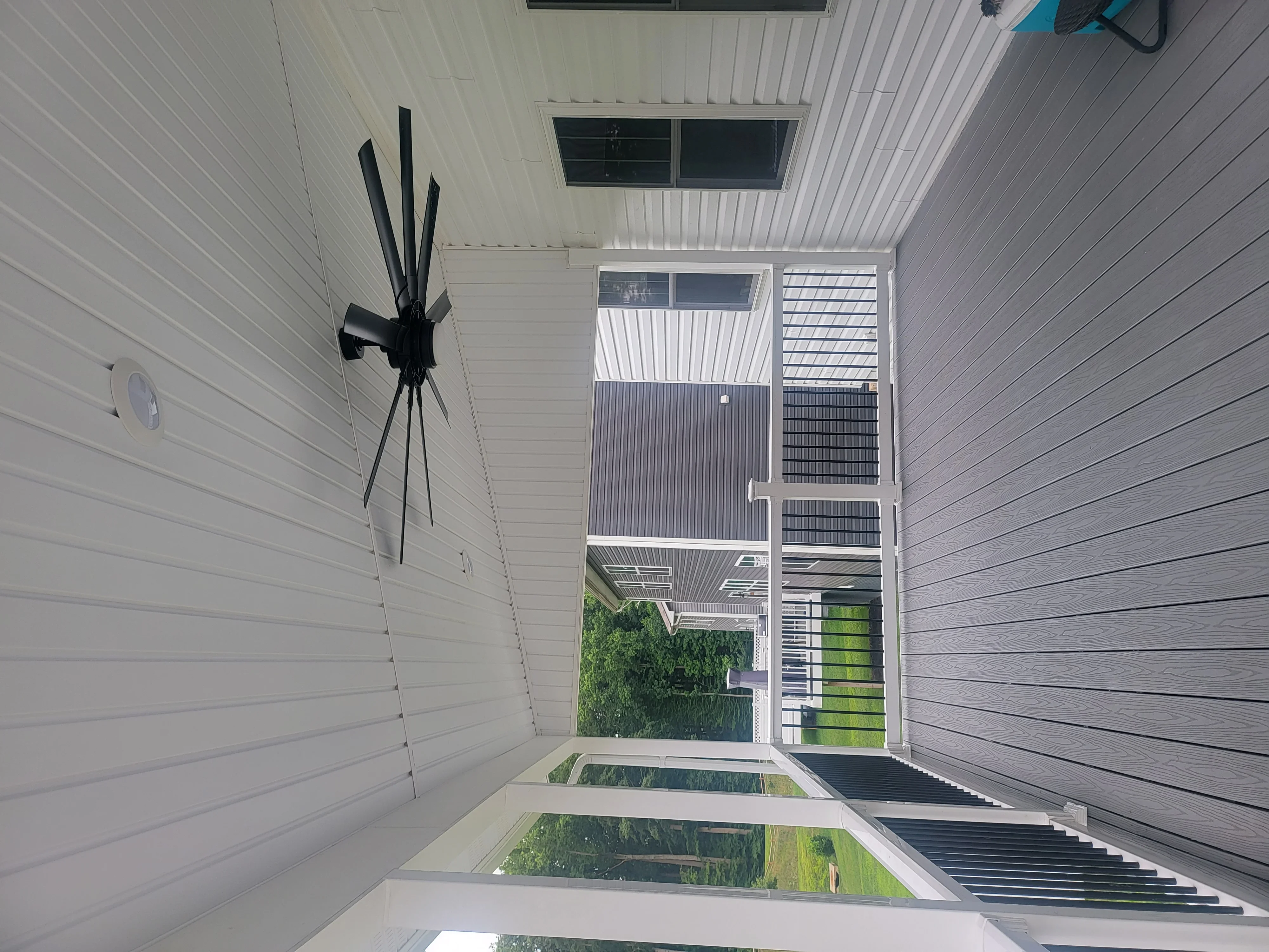 Modern composite deck with white boards, dark railings, and skylights overhead